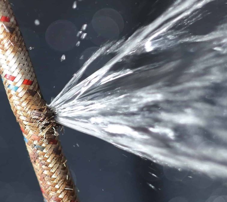 Burst flexible hose pipe with J&G Plumbing SOlutions plumber fixing the hose