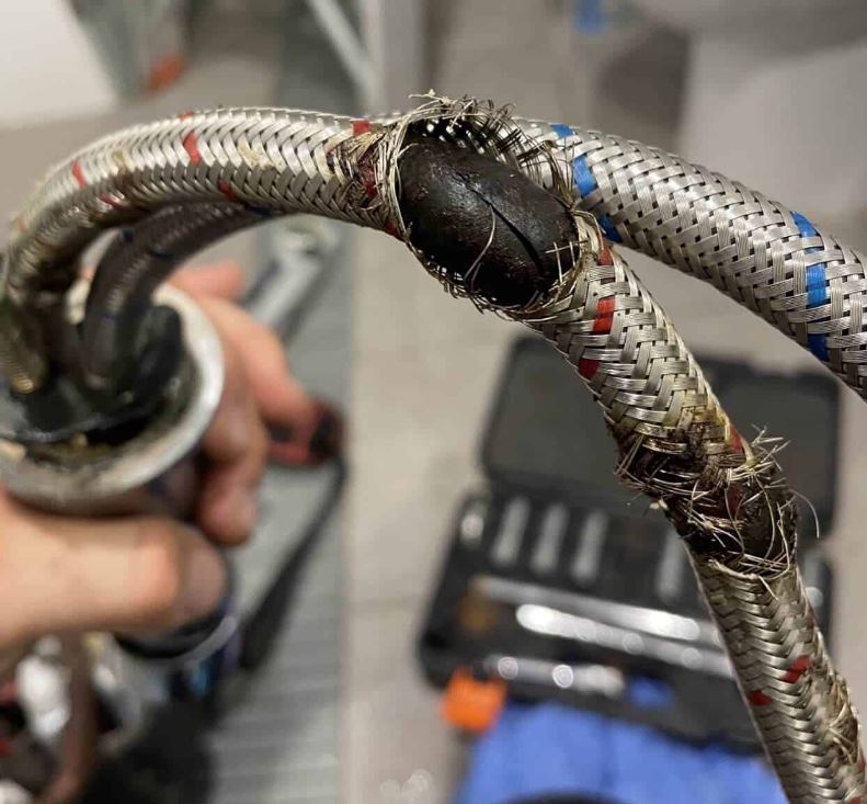 Burst washing machine hose with J&G Plumbing Solutions plumber fixing it