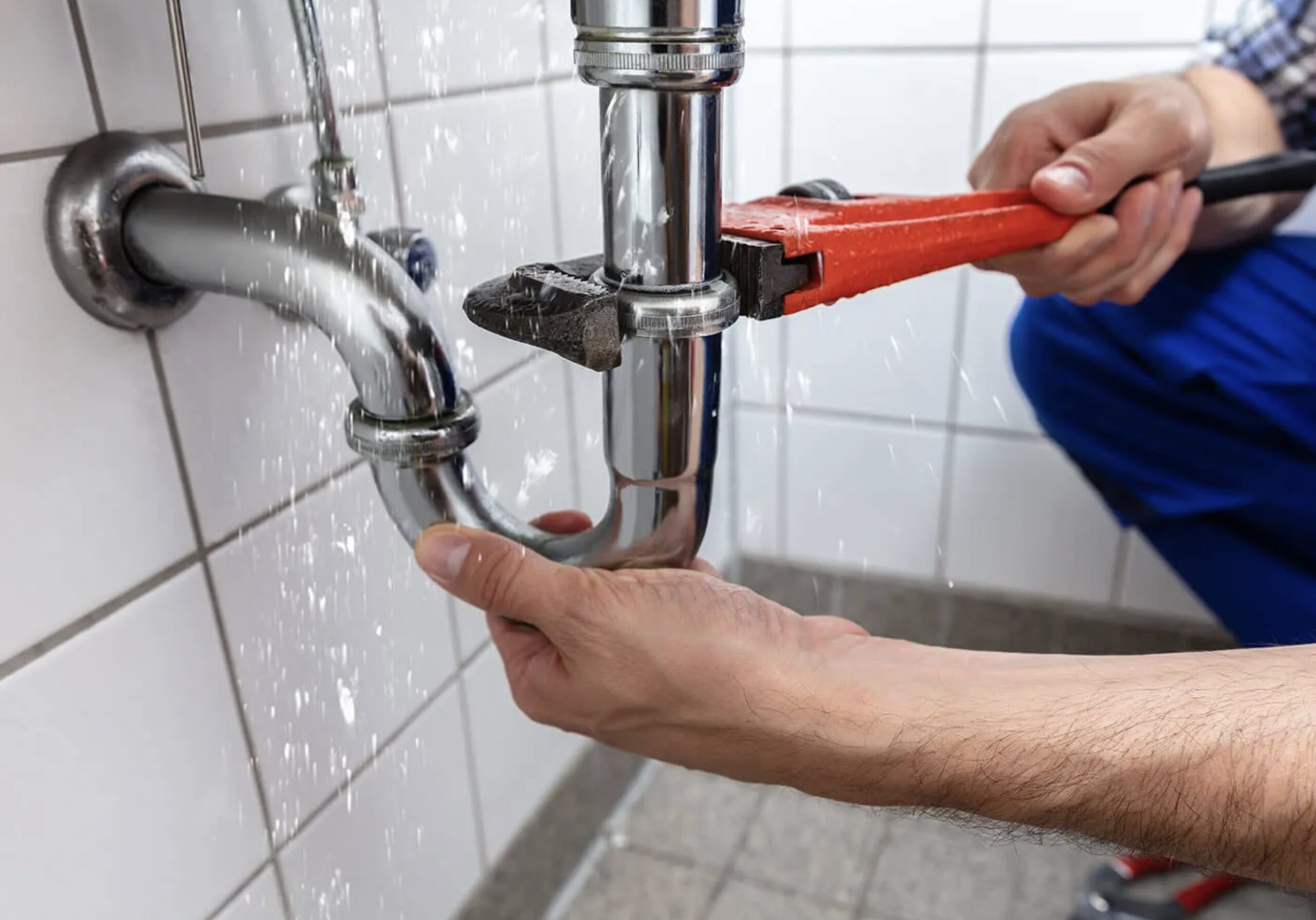 J&G Plumbing Solutions with a wrench fixing a leaking bathroom tap